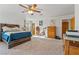 Bedroom featuring a ceiling fan, ensuite, a wood bedframe, and carpet flooring at 1261 S Comstock St, Pahrump, NV 89048