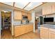 Galley kitchen featuring wooden cabinets, granite countertops, pantry, and plank flooring at 1261 S Comstock St, Pahrump, NV 89048