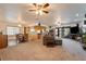Spacious living room featuring ceiling fans, carpet and view into the kitchen at 1261 S Comstock St, Pahrump, NV 89048