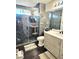 A modern bathroom with a tiled shower, a vanity and dark wood flooring with rugs at 1482 Flintrock Rd, Henderson, NV 89014