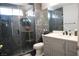 A modern bathroom with a tiled shower, a vanity with a white countertop, and dark wood flooring at 1482 Flintrock Rd, Henderson, NV 89014