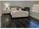 Spacious bedroom with dark wood flooring and large bed and a night stand and a crib at 1482 Flintrock Rd, Henderson, NV 89014