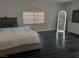 Bright bedroom with dark wood flooring, a large bed, a dresser and a large mirror at 1482 Flintrock Rd, Henderson, NV 89014