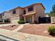 Charming two-story stucco house featuring a two-car garage, arched windows, and low-maintenance desert landscaping at 1482 Flintrock Rd, Henderson, NV 89014