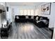 Spacious living room features modern gray flooring and a large, comfortable black sectional sofa at 1482 Flintrock Rd, Henderson, NV 89014
