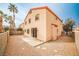 A backyard patio with a stucco wall surround and desert landscaping with palm trees in the distance at 1604 Tamborine Ct, Las Vegas, NV 89128