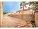 A backyard with a desert landscape and high concrete block wall surrounding the property at 1604 Tamborine Ct, Las Vegas, NV 89128