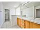 Bright bathroom with double sinks, tiled floors, and access to walk-in closet at 1604 Tamborine Ct, Las Vegas, NV 89128