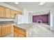 Open kitchen with a functional island, light wood cabinets, and a view into the adjacent living room at 1604 Tamborine Ct, Las Vegas, NV 89128