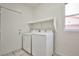 Bright laundry area features a washer and dryer, shelf, tiled floors, and a window for natural light at 1604 Tamborine Ct, Las Vegas, NV 89128