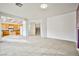 Open-concept living area with view into kitchen, neutral tile flooring, and natural light at 1604 Tamborine Ct, Las Vegas, NV 89128