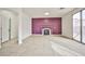Spacious living room with purple accent wall, fireplace, neutral tile flooring, and large sliding glass door at 1604 Tamborine Ct, Las Vegas, NV 89128