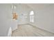 Bright, open living room with a high ceiling, light wood flooring, and a large arched window at 1604 Tamborine Ct, Las Vegas, NV 89128