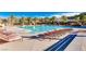 Large swimming pool with lounge chairs and palm trees on a sunny day with mountains in the background at 17 Winding Rd, Henderson, NV 89052