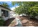 Charming backyard featuring mature shade tree and concrete walkway around perimeter of home at 1878 Corvette St, Las Vegas, NV 89142