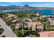 Aerial view of a single-story home with a red tile roof, landscaping, and waterfront scenery at 20 Via Paradiso St, Henderson, NV 89011