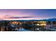 Beautiful lakefront homes with palm trees, lights and dock, and desert mountains in the background at sunset at 20 Via Paradiso St, Henderson, NV 89011