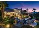Expansive backyard with a firepit area, outdoor kitchen, lush landscaping, and picturesque views at 20 Via Paradiso St, Henderson, NV 89011