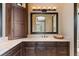 Elegant bathroom featuring dark wood cabinetry, tile countertops, and a large framed mirror at 20 Via Paradiso St, Henderson, NV 89011