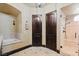 Well-lit bathroom featuring tiled floors, dual wooden doors, and a glass enclosed shower, providing a luxurious feel at 20 Via Paradiso St, Henderson, NV 89011