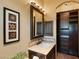 Lavish bathroom vanity with a framed mirror, tile accents, and custom dark wood cabinets at 20 Via Paradiso St, Henderson, NV 89011