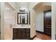 Bathroom featuring wooden cabinets, a marble countertop, an elegant mirror, and a glass shower, adding sophistication at 20 Via Paradiso St, Henderson, NV 89011
