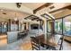 Spacious dining area with a stone fireplace, kitchen island, and access to the living room and outdoor spaces at 20 Via Paradiso St, Henderson, NV 89011
