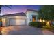 Home exterior with tile roof, and three-car garage with brick paved driveway at 20 Via Paradiso St, Henderson, NV 89011