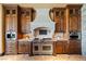 Elegant kitchen featuring custom cabinetry, a stone hood, and high-end stainless steel appliances at 20 Via Paradiso St, Henderson, NV 89011