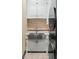 Well-appointed laundry room with white cabinets, stainless steel sink, and stacked washer and dryer at 20 Via Paradiso St, Henderson, NV 89011