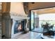 Cozy living room featuring a stone fireplace, large glass door, and outdoor seating area access at 20 Via Paradiso St, Henderson, NV 89011