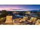 Relaxing outdoor lounge featuring plush seating, a fire pit, and serene lake views at sunset at 20 Via Paradiso St, Henderson, NV 89011