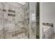 Modern bathroom shower with tiled walls, a glass door, and convenient storage racks at 200 Hoover Ave # 1905, Las Vegas, NV 89101