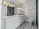Modern bathroom features a double sink vanity, sleek white cabinets, quartz counters, and decorative floor tiles at 21 Sawgrass Ct, Las Vegas, NV 89113