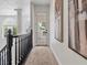 Bright hallway with staircase and railing, neutral carpet, and modern artwork providing an airy and stylish transition at 21 Sawgrass Ct, Las Vegas, NV 89113