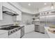 Bright kitchen features white cabinets, marble countertops, stainless steel appliances, and a large island for cooking at 21 Sawgrass Ct, Las Vegas, NV 89113