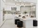 Contemporary kitchen features white cabinets, modern appliances, marble floors, and a stylish kitchen island with bar stools at 21 Sawgrass Ct, Las Vegas, NV 89113