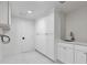 Well-organized laundry room with white cabinetry, sink, and modern finishes at 21 Sawgrass Ct, Las Vegas, NV 89113