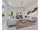 Bright living room featuring modern sofas, stylish chandelier, and large windows at 21 Sawgrass Ct, Las Vegas, NV 89113