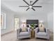 Inviting main bedroom featuring dual seating, a ceiling fan, and glimpses of a spa-like ensuite bathroom at 21 Sawgrass Ct, Las Vegas, NV 89113