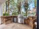 Built-in outdoor kitchen featuring a stainless steel grill, mini-fridge, and unique rock accents for stylish outdoor cooking at 21 Sawgrass Ct, Las Vegas, NV 89113
