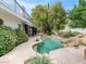 Inviting backyard pool area surrounded by lush greenery and unique rock formations creates a serene oasis at 21 Sawgrass Ct, Las Vegas, NV 89113