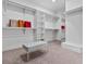 Large walk-in closet featuring custom built-in shelving, a gray bench, carpeted flooring, and natural light at 21 Sawgrass Ct, Las Vegas, NV 89113