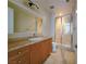 Bathroom featuring a glass shower and vanity with tan granite countertops, cabinet storage, and large mirror at 21 Via Visione # 206, Henderson, NV 89011