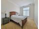 Bright bedroom with a window, carpeted floors, a wood frame bed, and matching bedside tables at 21 Via Visione # 206, Henderson, NV 89011