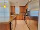 Open kitchen featuring stainless appliances, light wood floors, tan tile backsplash, and granite countertops at 21 Via Visione # 206, Henderson, NV 89011