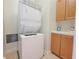 Bright laundry room with stacked washer and dryer and cabinets at 21 Via Visione # 206, Henderson, NV 89011