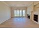 Spacious living room featuring stone fireplace, hardwood floors and sliding glass doors to the outdoor patio at 21 Via Visione # 206, Henderson, NV 89011