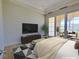 Staged bedroom features outdoor patio access, neutral carpet and walls, with large screen television at 21 Via Visione # 206, Henderson, NV 89011