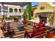 Outdoor patio with comfortable seating, a fireplace, lush landscaping, and elegant architectural details at 21 Via Visione # 206, Henderson, NV 89011